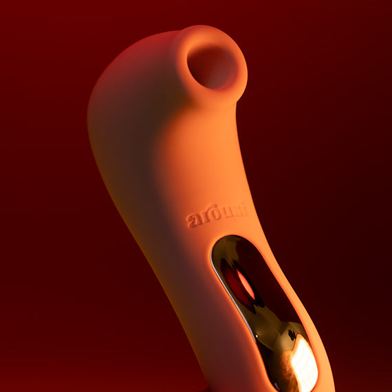 Arousi Inara air-pressure clitoral stimulator held at an angle, showing its soft suction rim